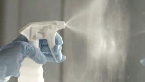 Spray bottle spraying cleaning materials against a window