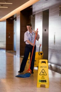 CCS Employee mopping the floor by an elevator