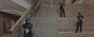 Grayed out photo of three ccs employees cleaning the stairs of a corporate facility