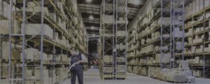 grayed out photo of a ccs employee vacuuming a distribution facility