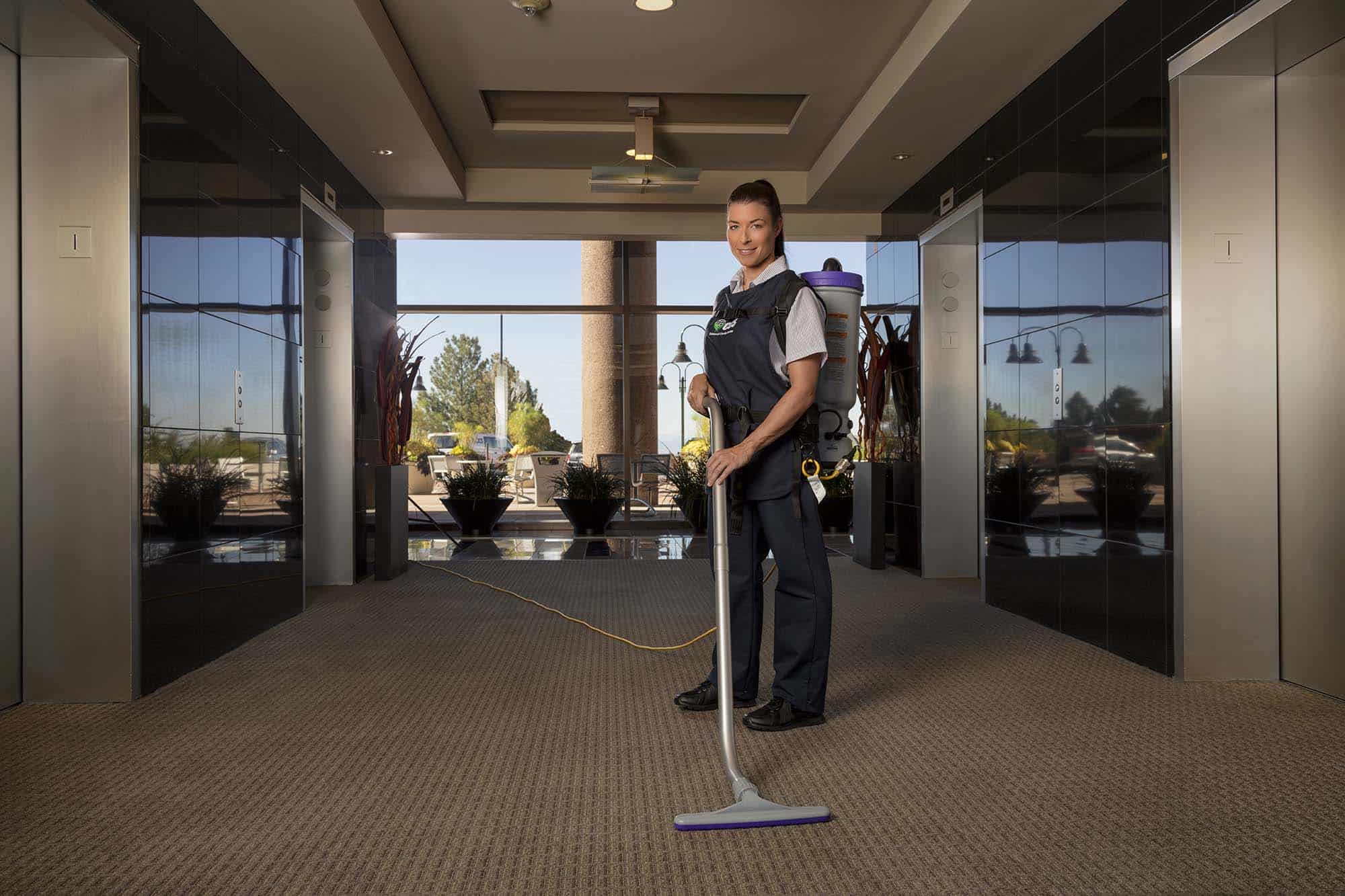 CCS Lady vacuuming an office hallway