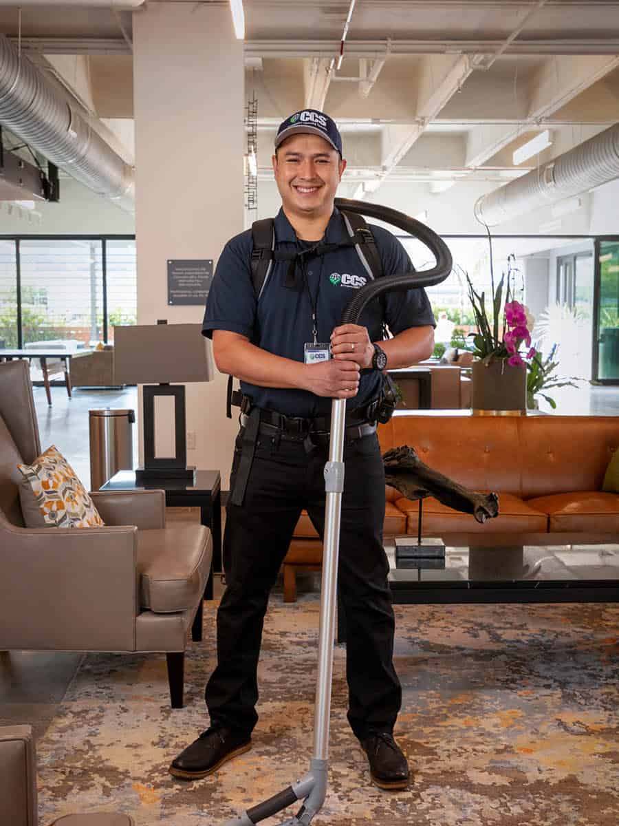 tools of the trade janitorial man standing with vacuum floorcare