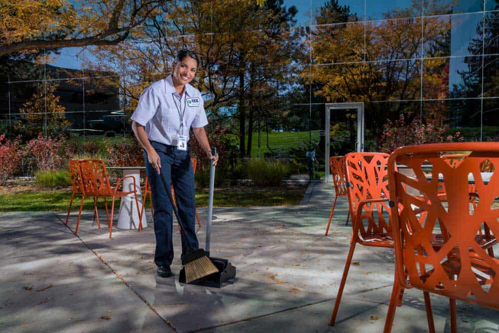 ccs employee wiping down a picnic table outside of an educational facility