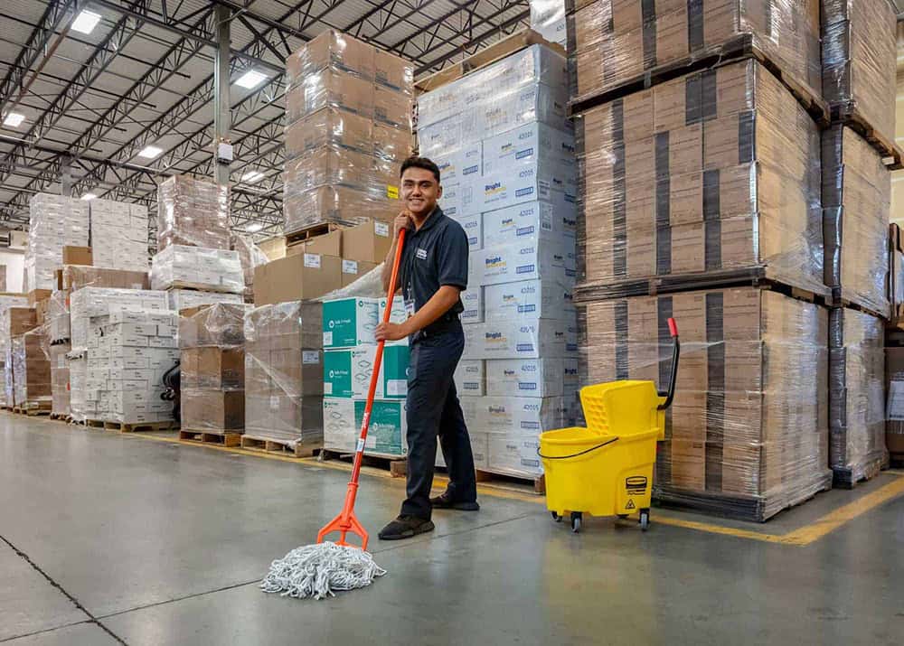 ccs employee moping the entrance to a building